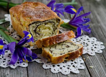 Cinnamon Swirl Bread on a Wooden Table and White Doilie with Blue Irises