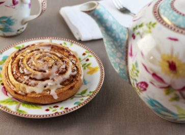 Cinnamon Roll on a Flowered China Plate with a matching colorful Teapot