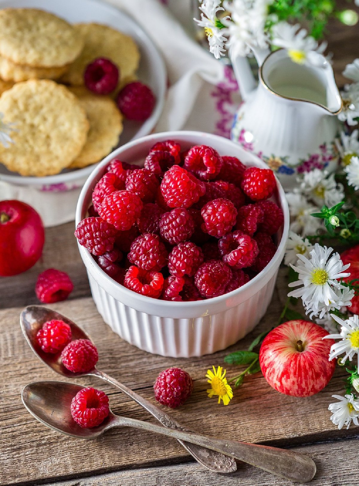 Fresh Red Raspberries in White Dish and Cream Pitcher, Spoons, Cookies, and White Flowers